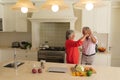 Senior caucasian couple dancing together and smiling in kitchen Royalty Free Stock Photo