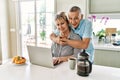 Senior caucasian couple having breakfast using laptop at the kitchen Royalty Free Stock Photo