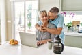 Senior caucasian couple having breakfast using laptop at the kitchen Royalty Free Stock Photo