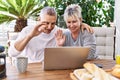 Senior caucasian couple having breakfast and video call using laptop at the terrace Royalty Free Stock Photo