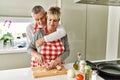 Senior caucasian couple hugging and cooking at the kitchen Royalty Free Stock Photo