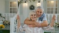 Senior couple together in front yard at home. Man swinging woman. Happy mature retired family Royalty Free Stock Photo