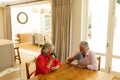 Senior caucasian couple sitting at table together drinking coffee in kitchen Royalty Free Stock Photo