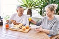 Senior caucasian couple smiling happy having breakfast at the terrace Royalty Free Stock Photo