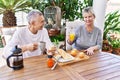 Senior caucasian couple smiling happy having breakfast at the terrace Royalty Free Stock Photo