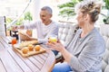 Senior caucasian couple smiling happy having breakfast at the terrace Royalty Free Stock Photo