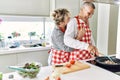 Senior caucasian couple smiling happy and hugging cooking at the kitchen Royalty Free Stock Photo