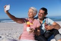 Senior Caucasian couple taking a selfie at the beach. Royalty Free Stock Photo