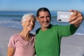 Senior Caucasian couple taking a selfie at the beach. Royalty Free Stock Photo