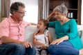 Senior Caucasian couple watching a family album at home with their granddaughter Royalty Free Stock Photo