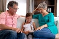 Senior Caucasian couple watching a family album at home with their granddaughter Royalty Free Stock Photo