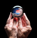 Hands holding a crystal glass forecasting ball to predict the result of the election Royalty Free Stock Photo