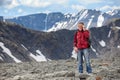 Senior Caucasian hiker with backpack talking on cellphone in the mountains, copy space Royalty Free Stock Photo