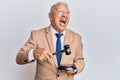 Senior caucasian judge man using gavel angry and mad screaming frustrated and furious, shouting with anger Royalty Free Stock Photo