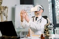 Senior Caucasian male doctor, scientist, virologist, wearing virtual reality glasses for imagination, conducting Royalty Free Stock Photo