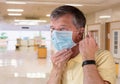 Senior man adjusting face mask and looking very worried about the epidemic Royalty Free Stock Photo