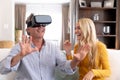 Senior Caucasian man and his adult daughter using a VR headset at home Royalty Free Stock Photo