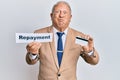 Senior caucasian man holding payment word paper and credit card puffing cheeks with funny face Royalty Free Stock Photo