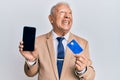 Senior caucasian man holding smartphone and credit card angry and mad screaming frustrated and furious, shouting with anger Royalty Free Stock Photo