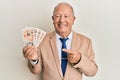 Senior caucasian man holding united kingdom pounds smiling happy pointing with hand and finger