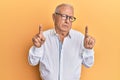 Senior caucasian man pointing up with fingers clueless and confused expression Royalty Free Stock Photo