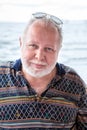 Senior Caucasian man portrait with white beard and blond hairs, sun glasses, looking at camera