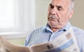 Senior Caucasian man reading a newspaper at home Royalty Free Stock Photo