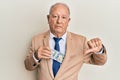 Senior caucasian man saving money bribery with angry face, negative sign showing dislike with thumbs down, rejection concept Royalty Free Stock Photo