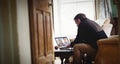 Senior caucasian man using laptop at home having video call with diverse students Royalty Free Stock Photo