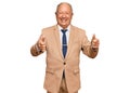 Senior caucasian man wearing business suit and tie approving doing positive gesture with hand, thumbs up smiling and happy for Royalty Free Stock Photo