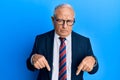 Senior caucasian man wearing business suit and tie pointing down looking sad and upset, indicating direction with fingers, unhappy Royalty Free Stock Photo