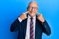 Senior caucasian man wearing business suit and tie smiling with open mouth, fingers pointing and forcing cheerful smile Royalty Free Stock Photo