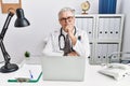 Senior caucasian man wearing doctor uniform and stethoscope at the clinic looking confident at the camera smiling with crossed Royalty Free Stock Photo