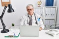 Senior caucasian man wearing doctor uniform and stethoscope at the clinic looking sleepy and tired, exhausted for fatigue and Royalty Free Stock Photo