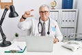 Senior caucasian man wearing doctor uniform and stethoscope at the clinic smiling and confident gesturing with hand doing small Royalty Free Stock Photo