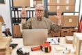 Senior caucasian man working at small business ecommerce with laptop showing and pointing up with fingers number eight while Royalty Free Stock Photo