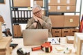 Senior caucasian man working at small business ecommerce with laptop sleeping tired dreaming and posing with hands together while Royalty Free Stock Photo