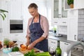 Senior caucasian woman cutting carrots while cooking food in kitchen at home Royalty Free Stock Photo