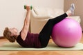 Senior woman exercising with dumbbells and fitness ball at home, healthy lifestyle, active elderly concept. Royalty Free Stock Photo