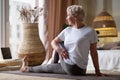 Senior caucasian woman in half spinal twist pose on mat Royalty Free Stock Photo