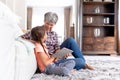 Senior Caucasian woman using a tablet at home with her granddaughter Royalty Free Stock Photo