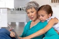 Senior Caucasian woman using a tablet at home with her granddaughter Royalty Free Stock Photo