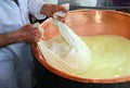 Senior cheesemaker collects the cheese with the tarp from the co