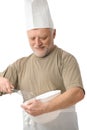 Senior chef whisking egg in kitchen Royalty Free Stock Photo