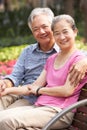 Senior Chinese Couple Relaxing On Park Bench Royalty Free Stock Photo