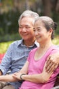 Senior Chinese Couple Relaxing On Park Bench Royalty Free Stock Photo