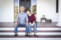 Senior Chinese Couple Sitting on Front Steps of Their House