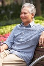 Senior Chinese Man Relaxing On Park Bench Royalty Free Stock Photo