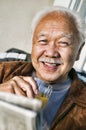 Senior chinese Man smiling while Drinking Orange Juice Royalty Free Stock Photo