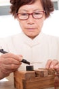 Senior Chinese seal carving artist at work Royalty Free Stock Photo